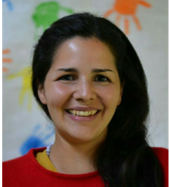Foto von Dianelisa Lazarde auf dem sie lächelt. Sie hat lange schwarze Haare, braune Augen und trägt einen roten Pullover.