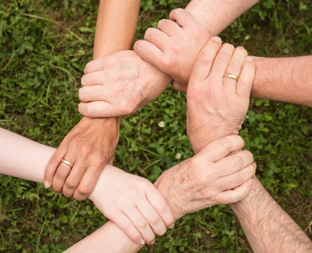 pexels-Foto auf dem ineinander verschränkte Unterarme zu sehen sind