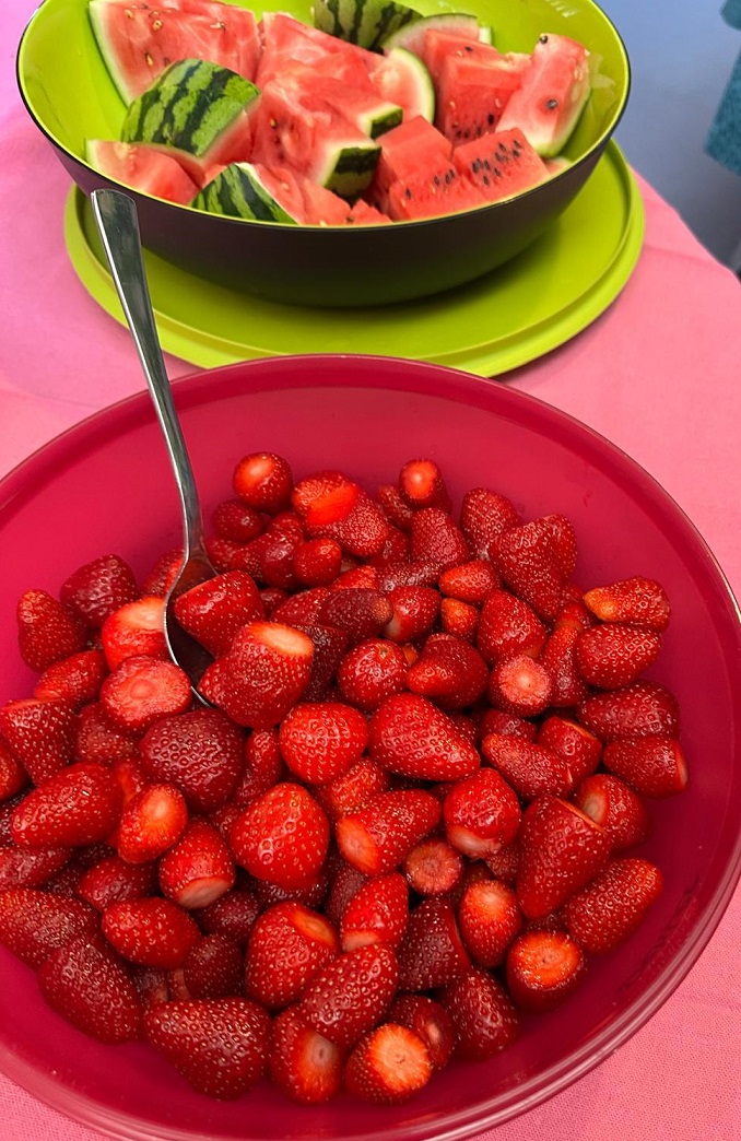 Foto von einer großen Schale mit Erdbeeren und einer Schale mit Melonenstücken im Hintergrund