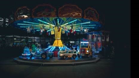Kinderkarussel das in der Dunkelheit durch die Lampen leuchtet